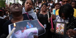 Mertilla Jones (l) weeps in agony at candlelight vigil for Aiyana shortly after her death; Aiyana's mother Dominika and father Charles are at right.