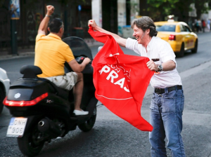 Jubilant 'NO' supporter waves flag of governing left-wing Syriza party.