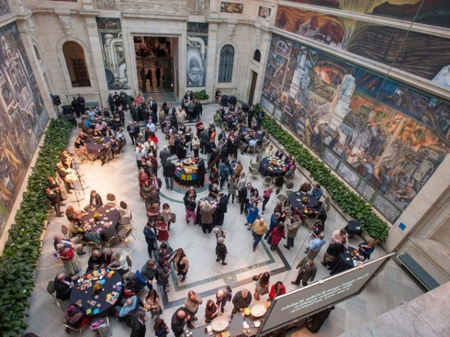 Wealthy partygoers celebrate opening of Frieda Kahlo-Diego Rivera art display in courtyard. Ironically, they partied in front of Rivera's mural celebrating Detroit workers and representing his Communist beliefs.