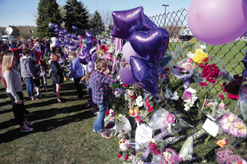 A memorial fence in memory of pop star Prince is lined with flowers and signs at Paisley Park Studios, April 22, in Chanhassen, Minn. Prince died April 21 at Paisley Park at the age of 57.