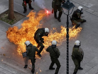 Riot police in Athens duck petrol bomb thrown by protesters Feb. 4, 2016