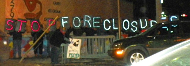 Protesters hold electric "Stop Foreclosures" sign across the street from Duggan State of the City address, Feb. 11, 2015.