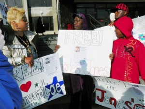 Aiyana Jones' grandmother (Mertilla Jones) listens as Taminko Sanford speaks during rally for their children April 23, 2012. Davontae's signs were made by Jones family member.