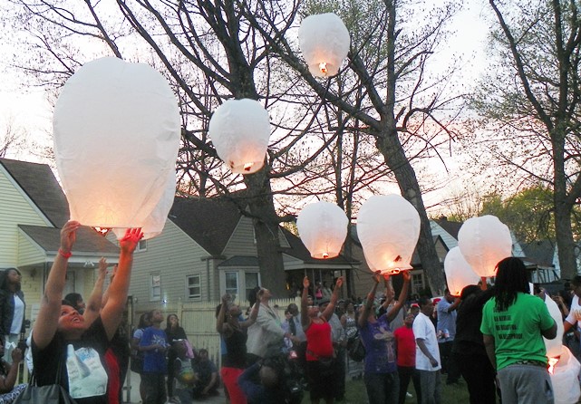 Crowd sends floating lanterns skyward in honor of 19-year-old father Terrance Kellom, who did not live to see his second child born.