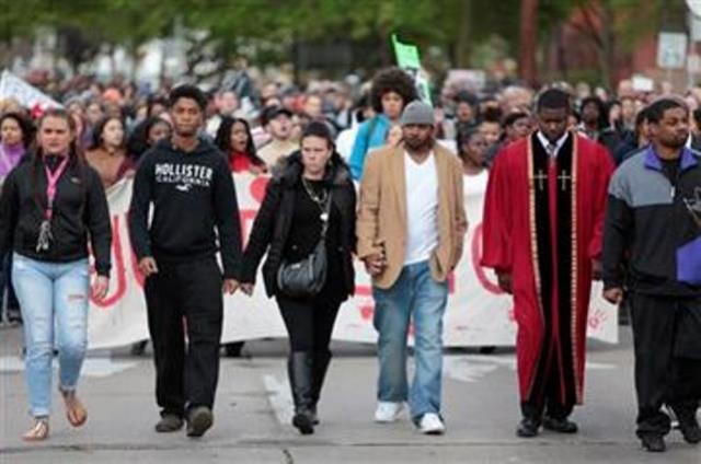 (M.P. King/Wisconsin State Journal via AP). Andrea Irwin, center, mother of Tony Robinson, and her boyfriend, Jeff Jackson, center right, participate in a protest march on Williamson Street, Tuesday, May 12, 2015, in Madison, Wis. Dane County District.